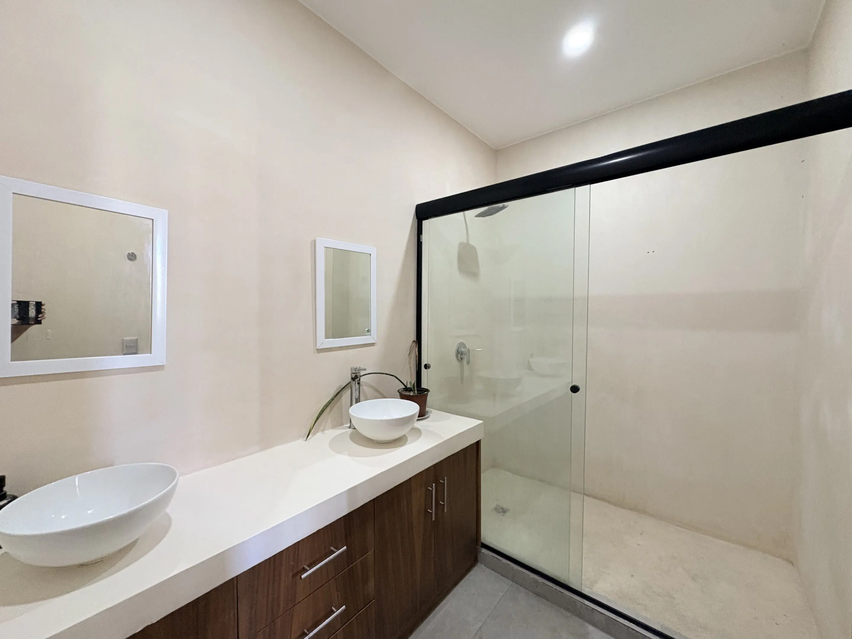 Modern bathroom with double vessel sinks, glass shower