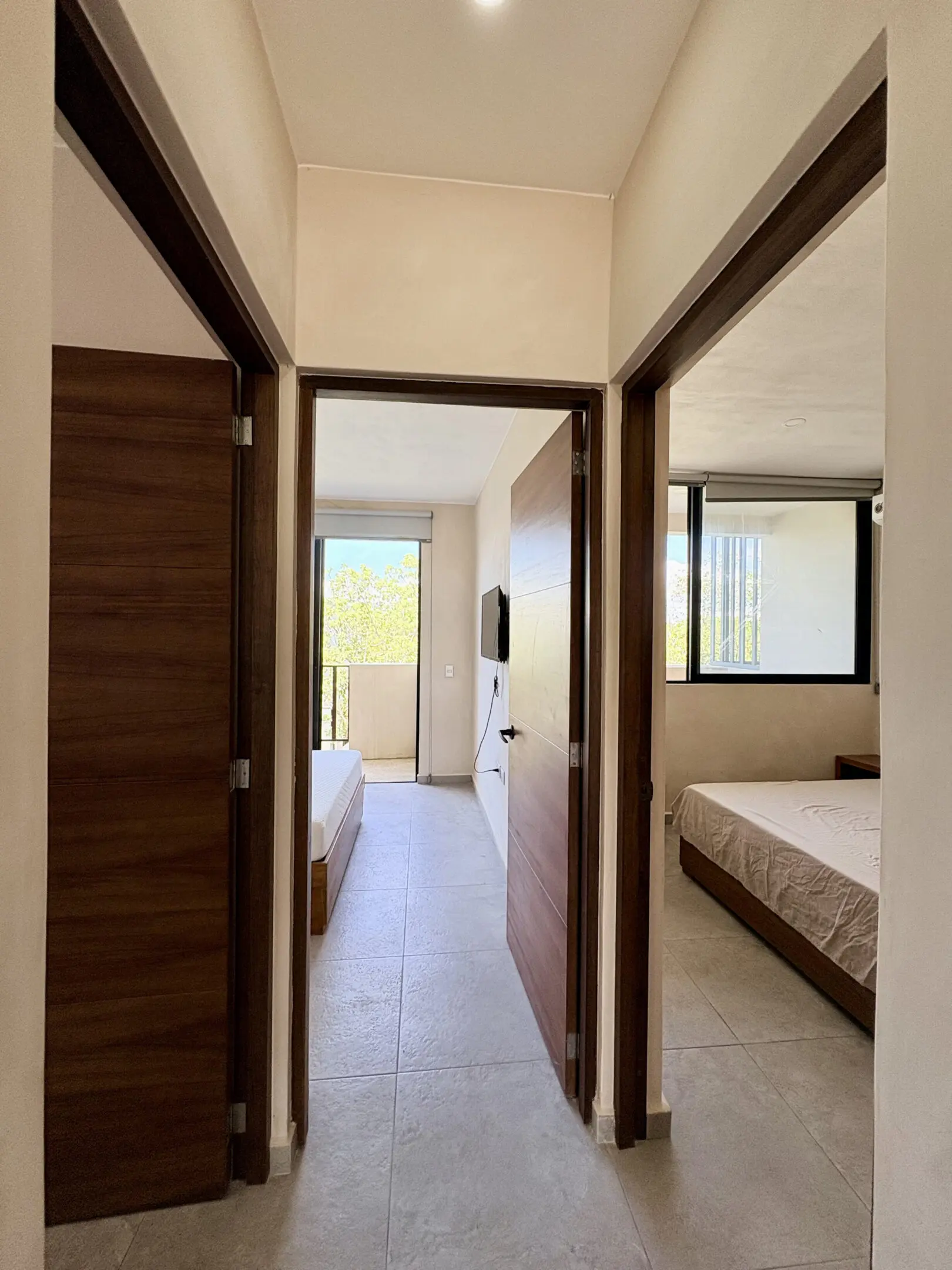 Hallway with two bedrooms and balcony view