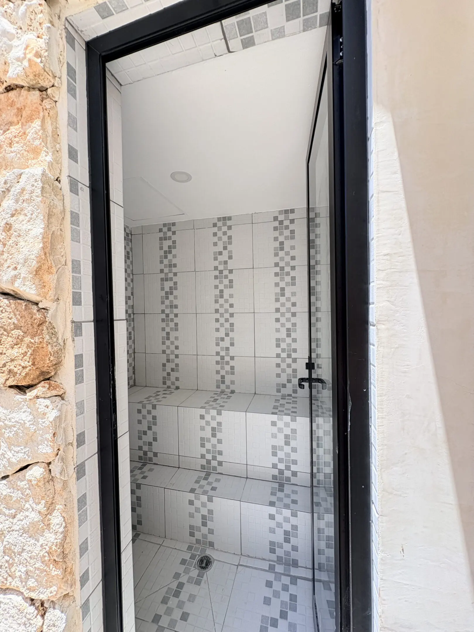 Modern tiled steam room with glass door