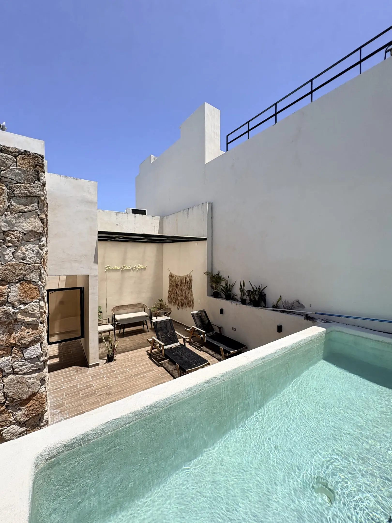 Sunlit rooftop pool terrace with lounge chairs