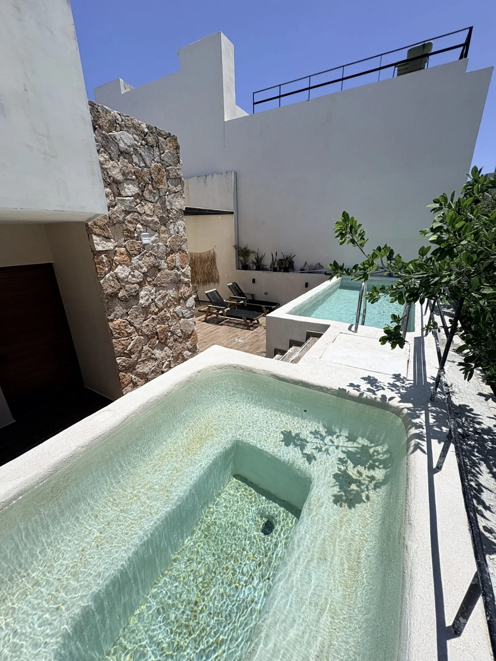 Sunlit villa terrace with two plunge pools