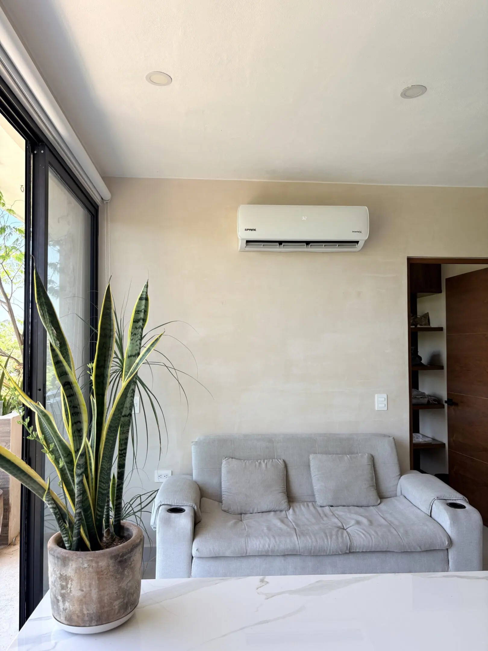 Living room sofa beneath wall-mounted air conditioner