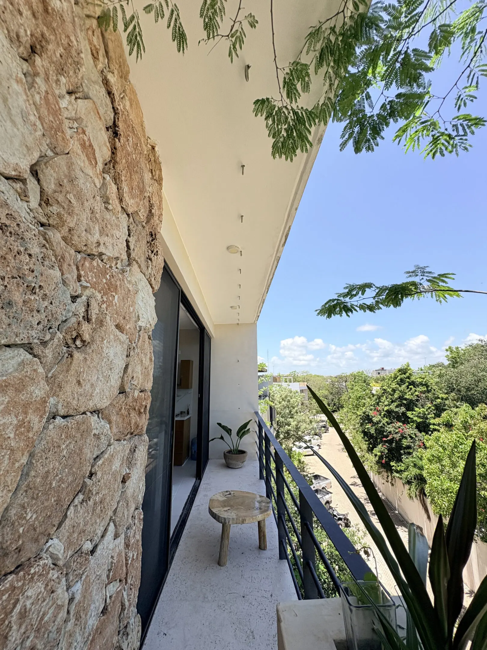 Sunlit balcony with stone wall and plants