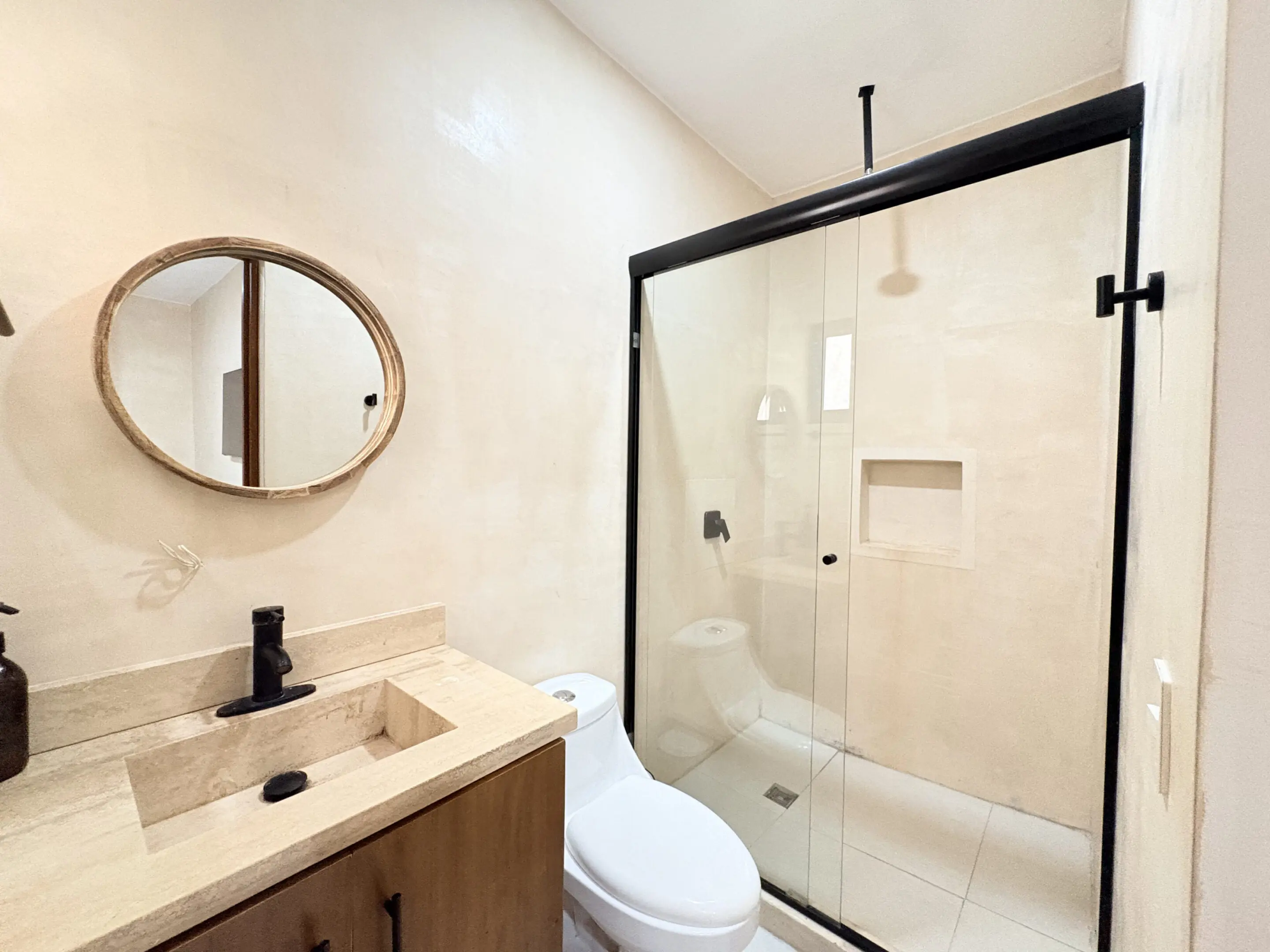 Modern beige bathroom with glass shower and vanity