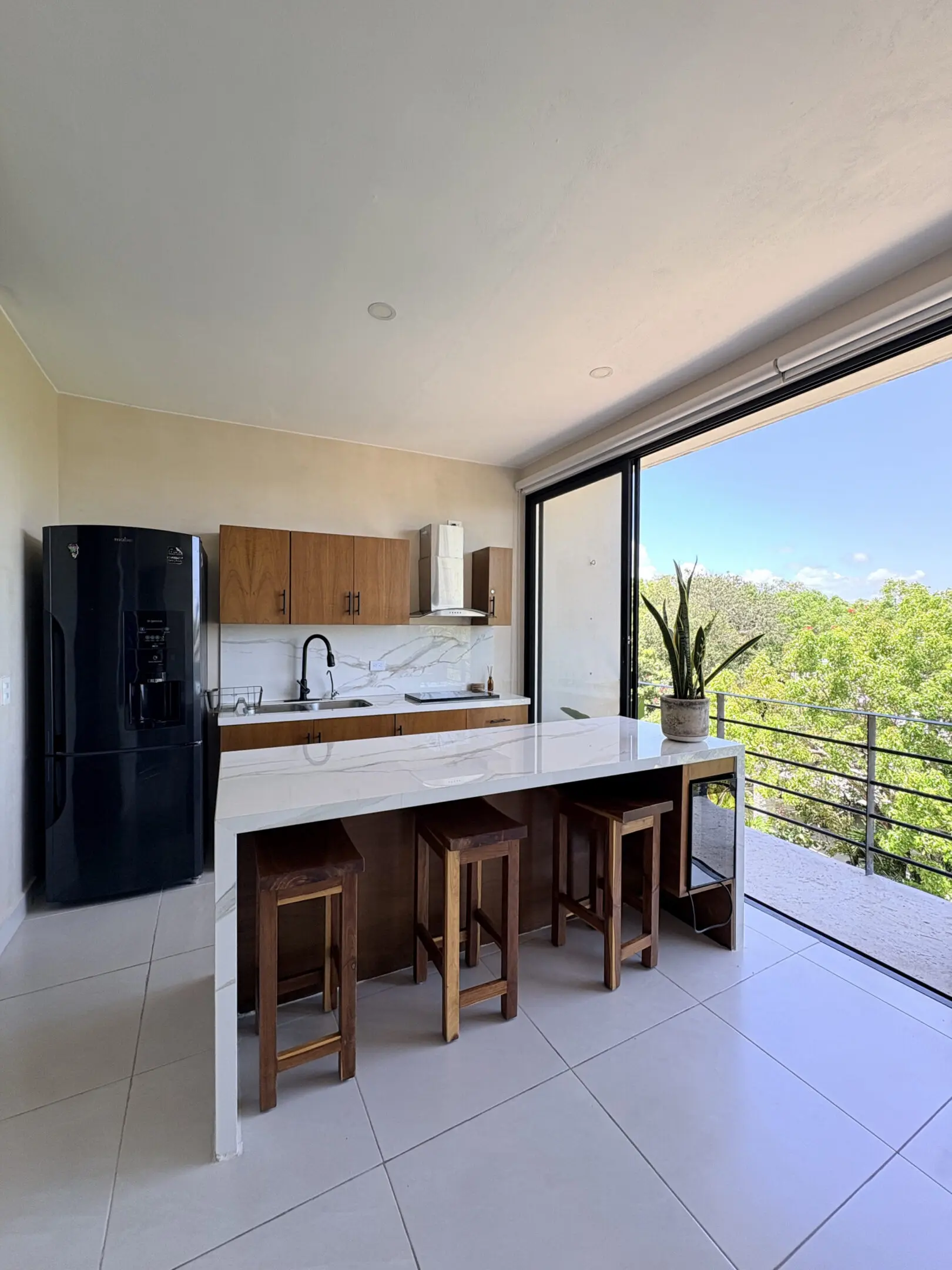 Modern kitchen island with stools and balcony