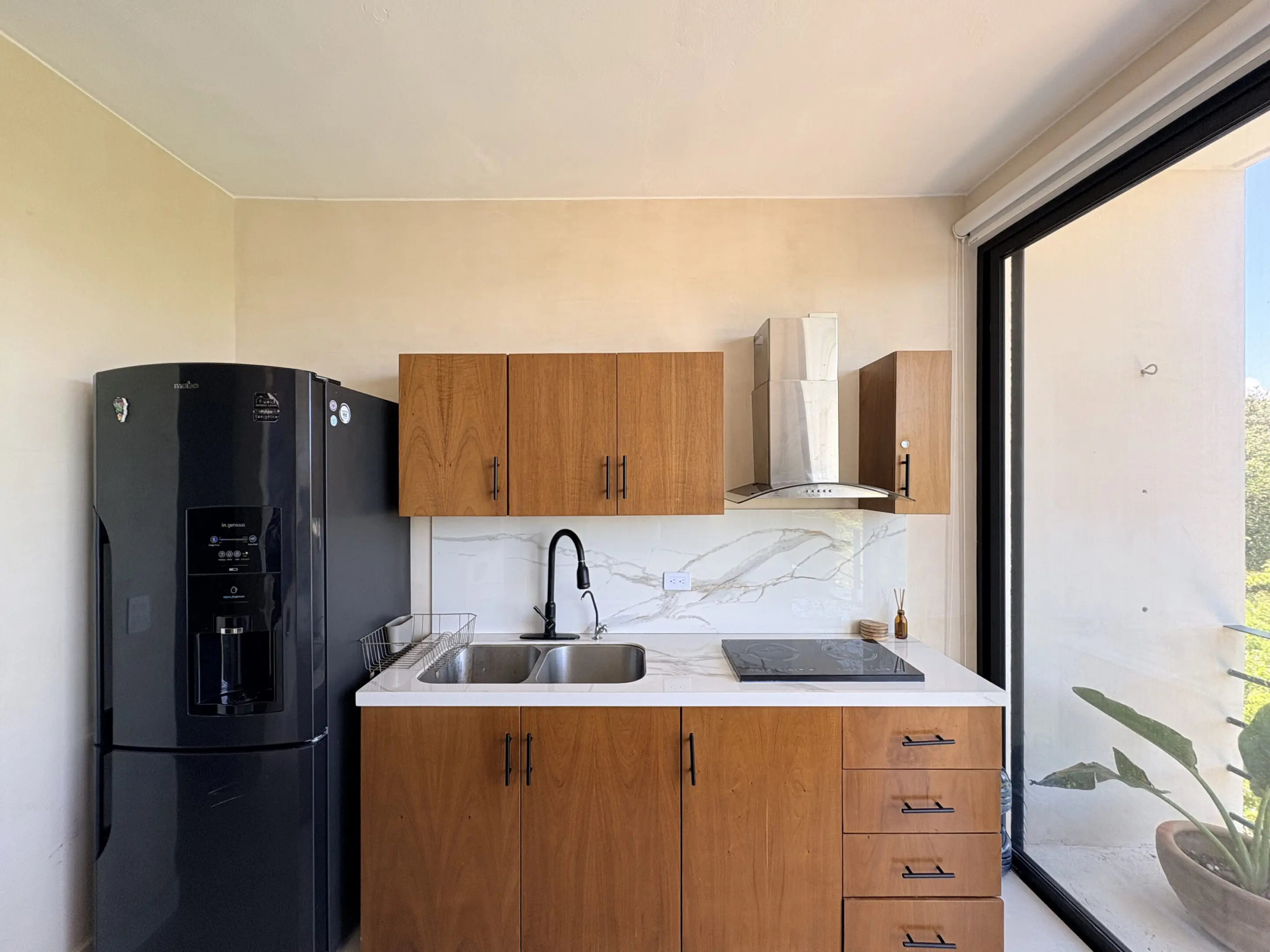 Modern kitchenette with wooden cabinets and fridge