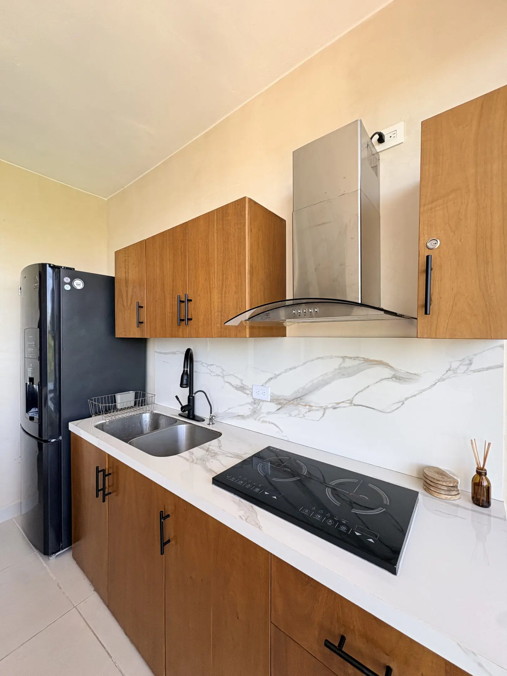 Kitchen with marble countertop, wooden cabinets, appliances
