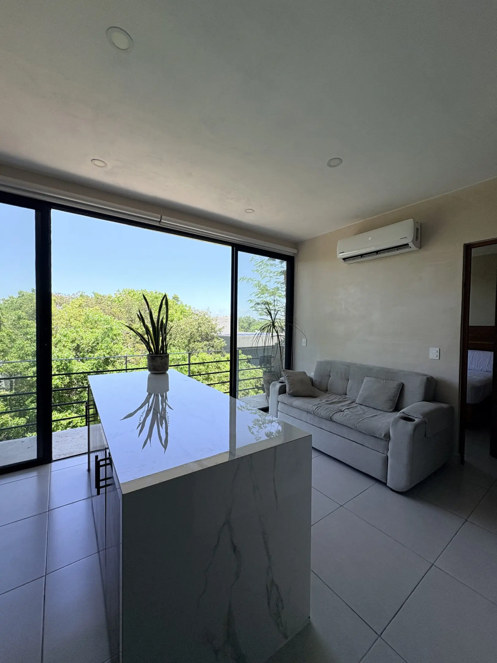 Modern living room with island and greenery view