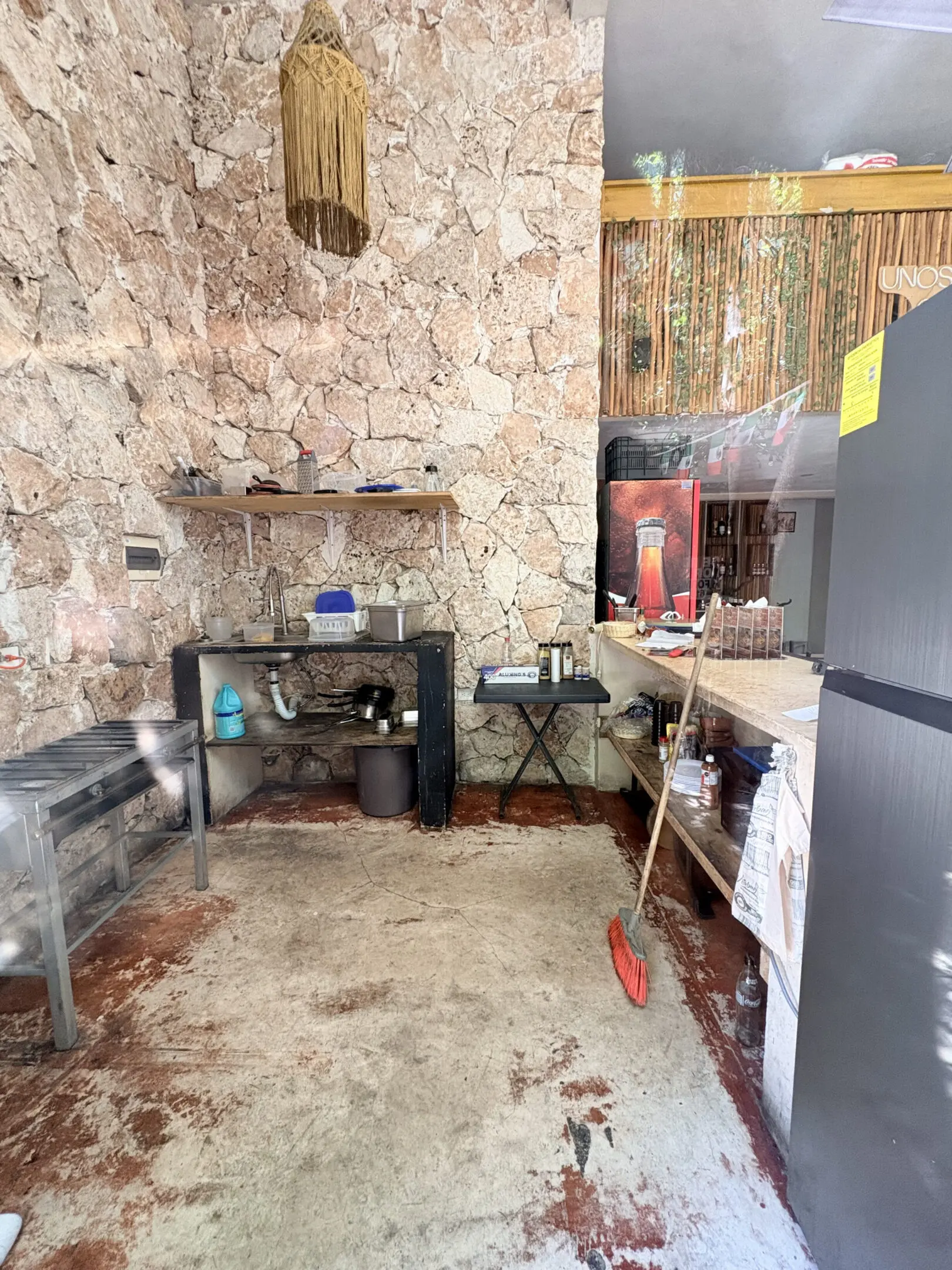 Rustic kitchenette with stone wall and refrigerator