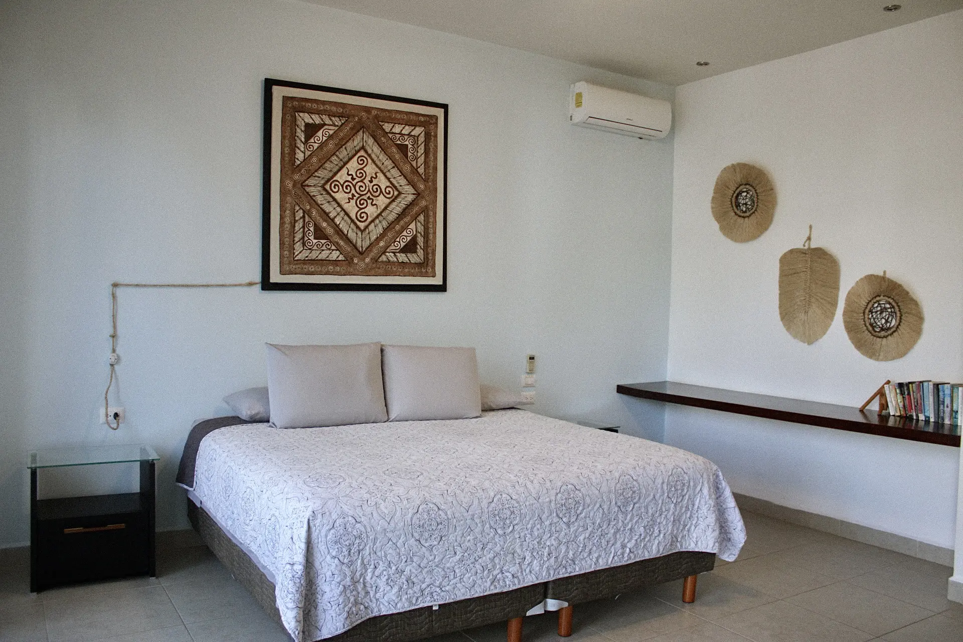 Minimalist bedroom with white bed and wall art