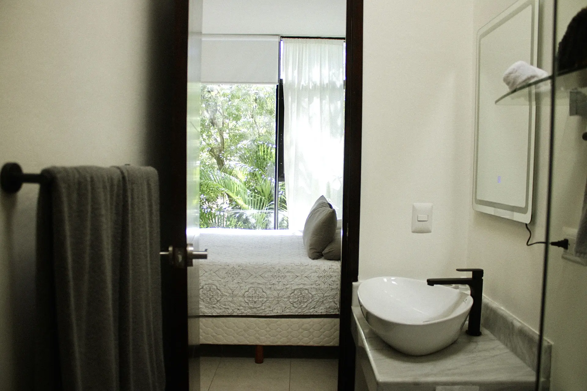 Modern bathroom doorway to bedroom with window
