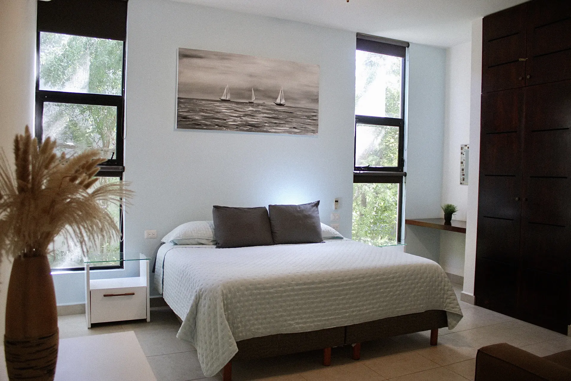 Modern bedroom with bed and sailboat painting