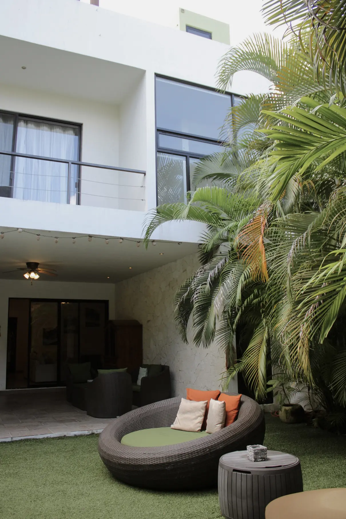 Cozy outdoor wicker daybed under tropical palms