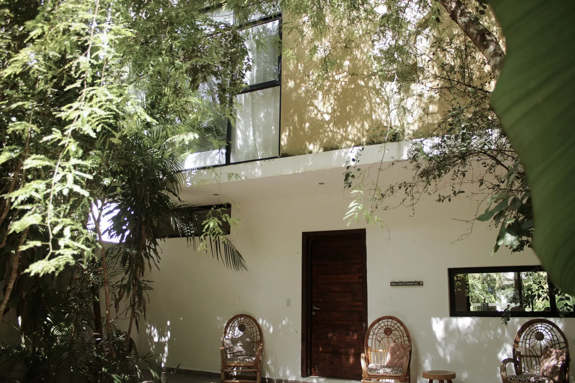 Tropical white house entrance with wicker chairs