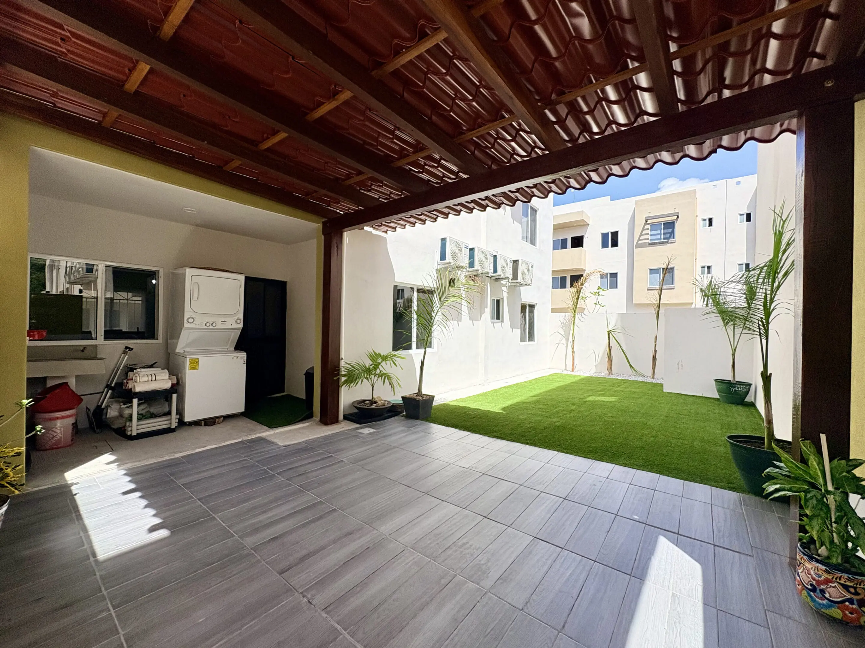 Covered patio with artificial lawn and laundry