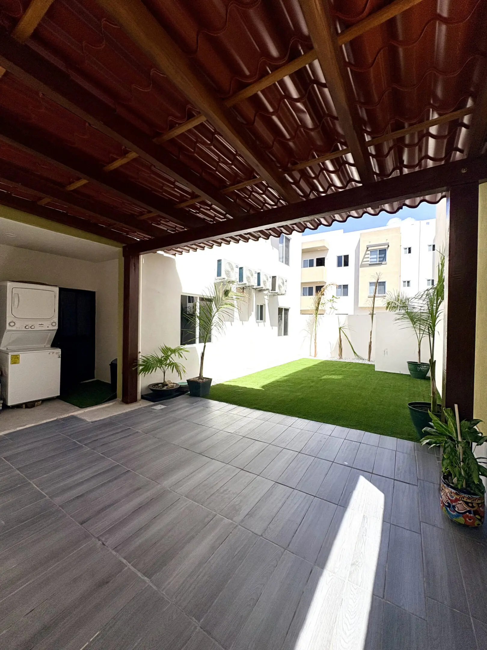 Covered patio with tiled floor and artificial lawn