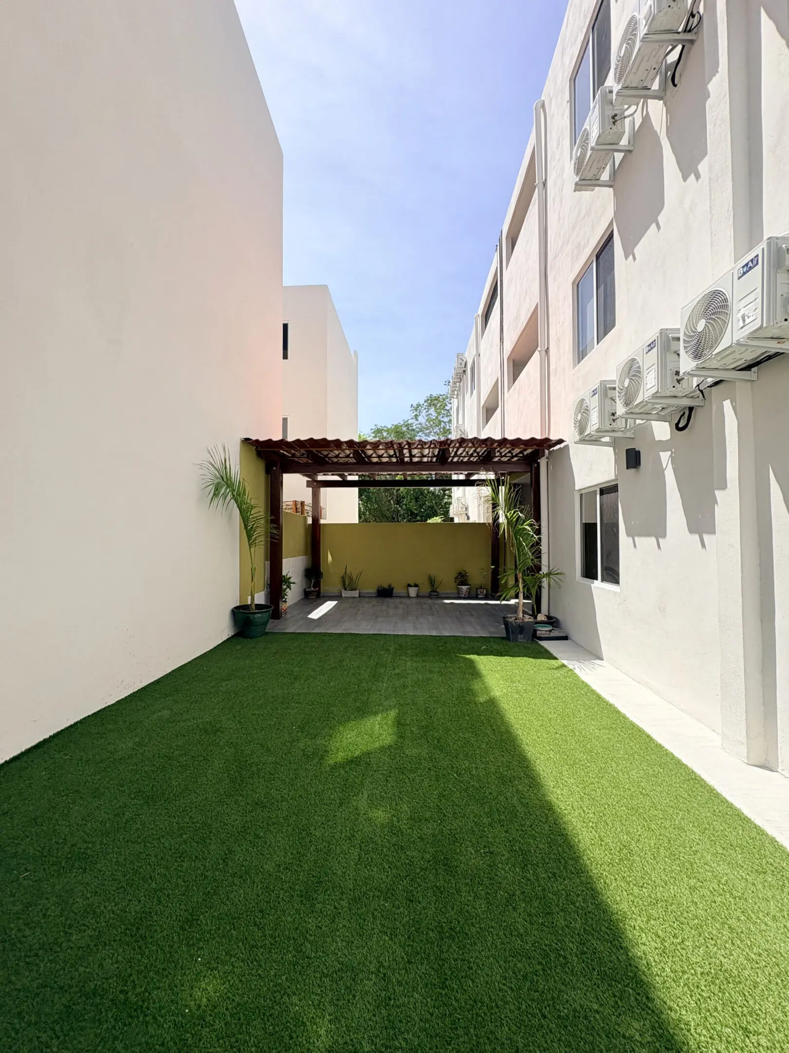 Modern courtyard with artificial turf and pergola
