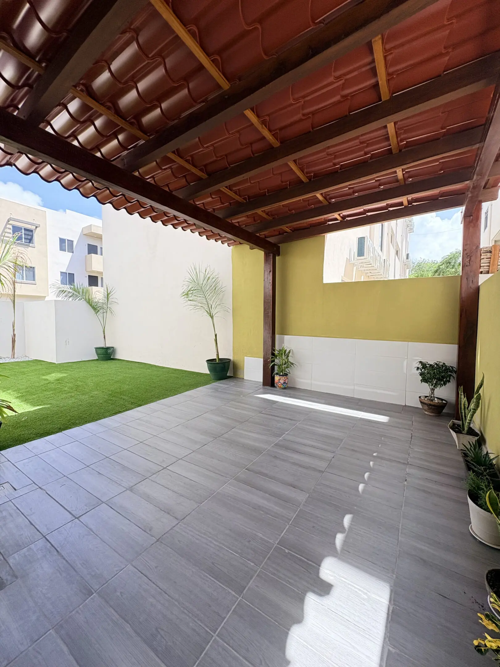 Covered patio with tiled floor and lawn