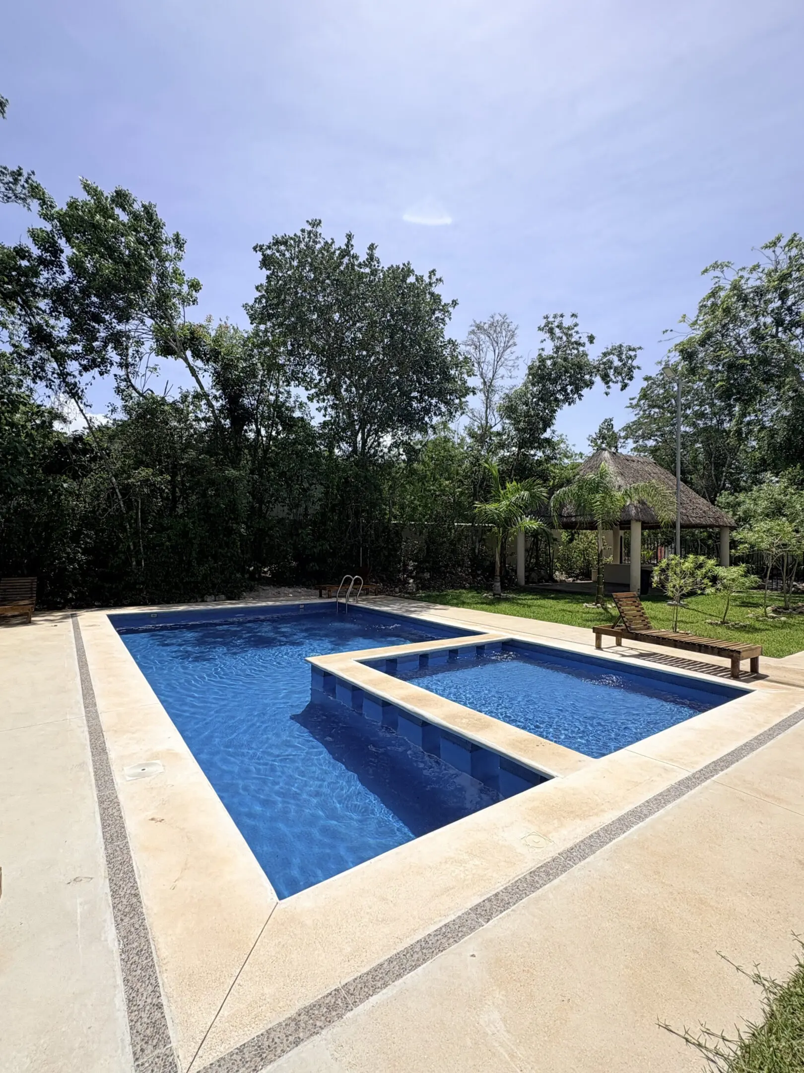Outdoor rectangular pool with gazebo and trees