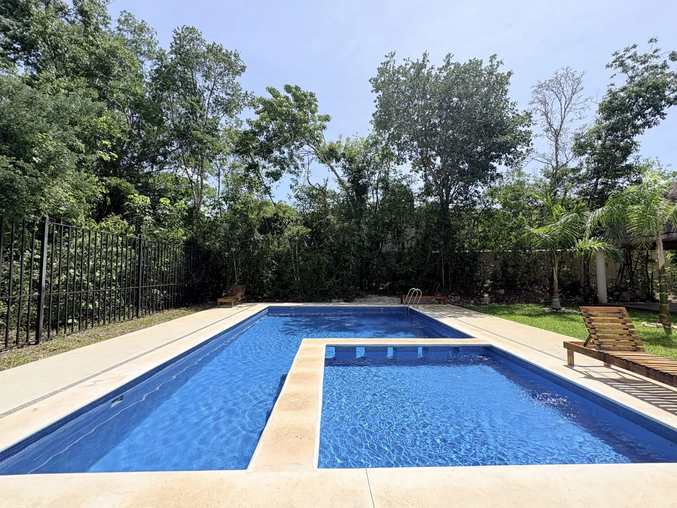 Backyard rectangular swimming pool with lounge chairs
