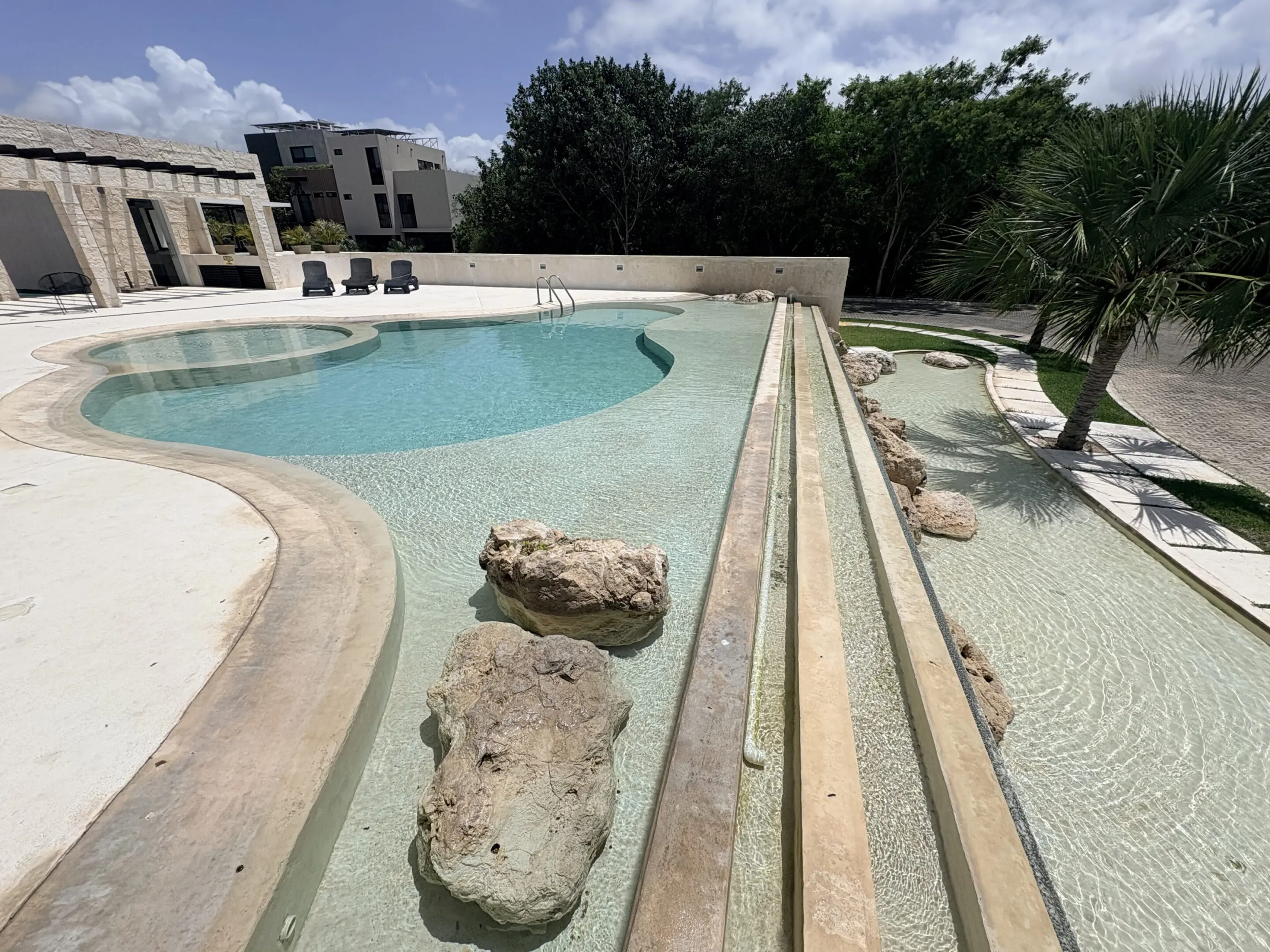 Luxury resort swimming pool with rocks and loungers