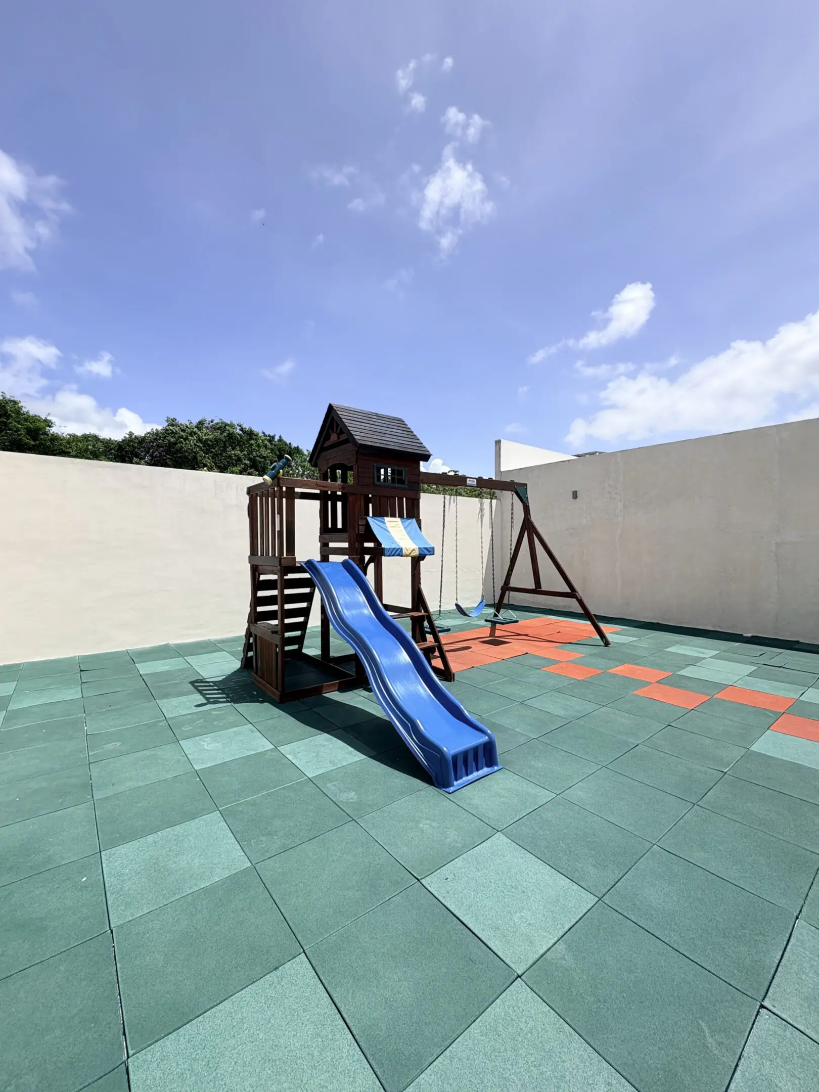 Backyard playground with blue slide and swing