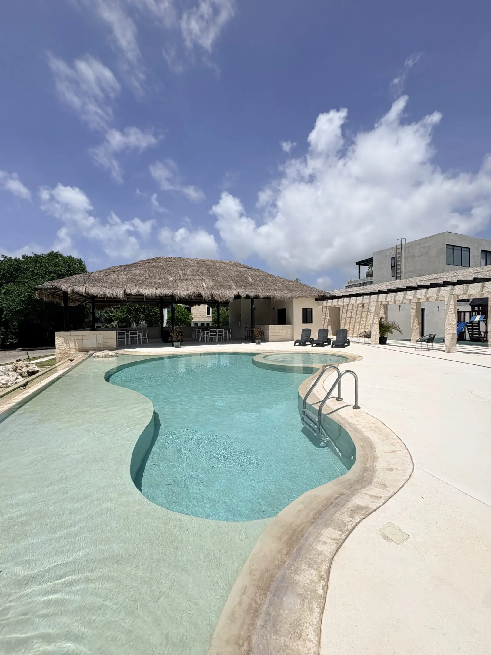 Resort swimming pool with palapa and loungers
