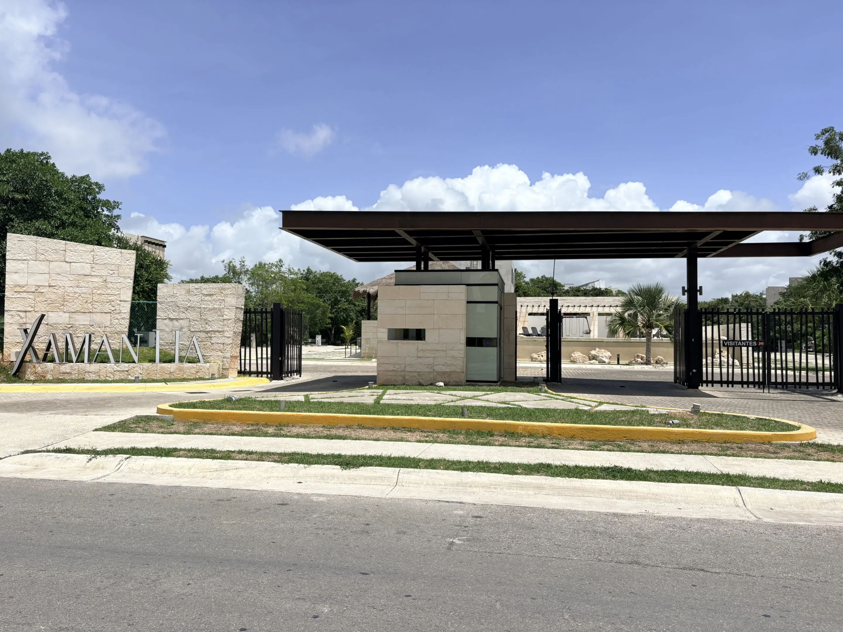 Modern gated entrance with stone sign