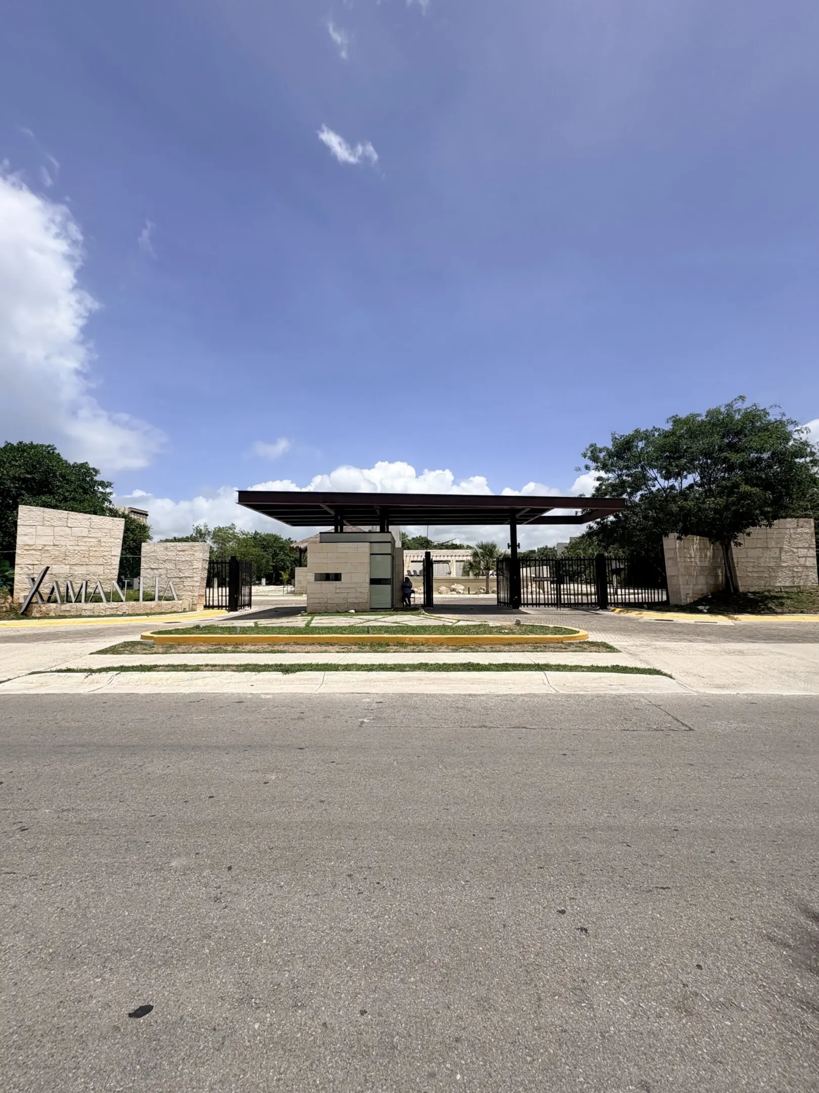 Modern gated entrance with canopy and landscaping