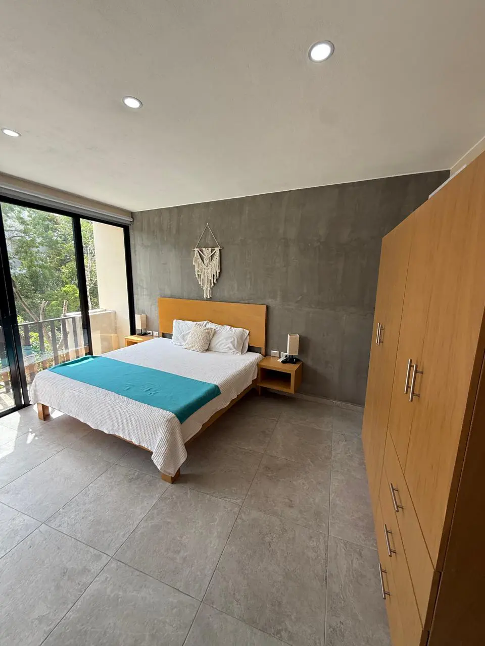 Modern minimalist bedroom with teal runner, balcony