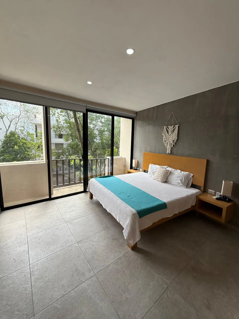 Modern bedroom with balcony and teal runner
