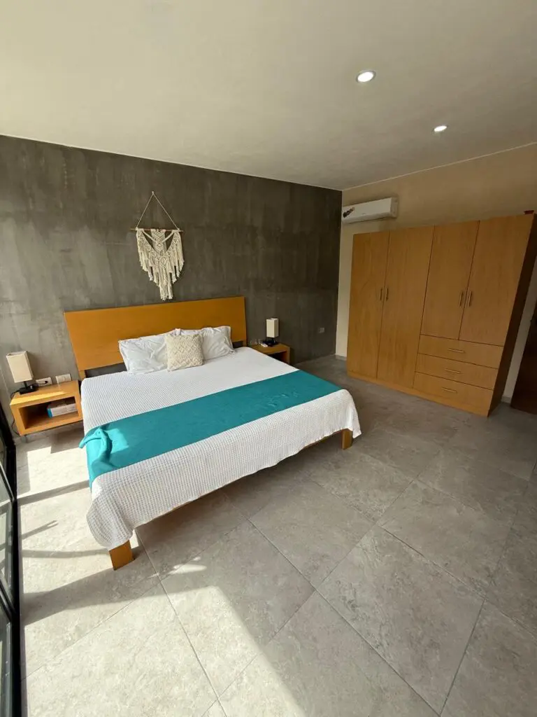 Modern minimalist bedroom with teal-accented king bed