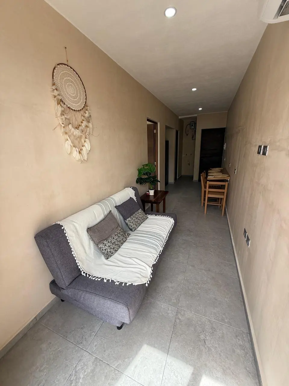 Narrow hallway with sofa and dreamcatcher