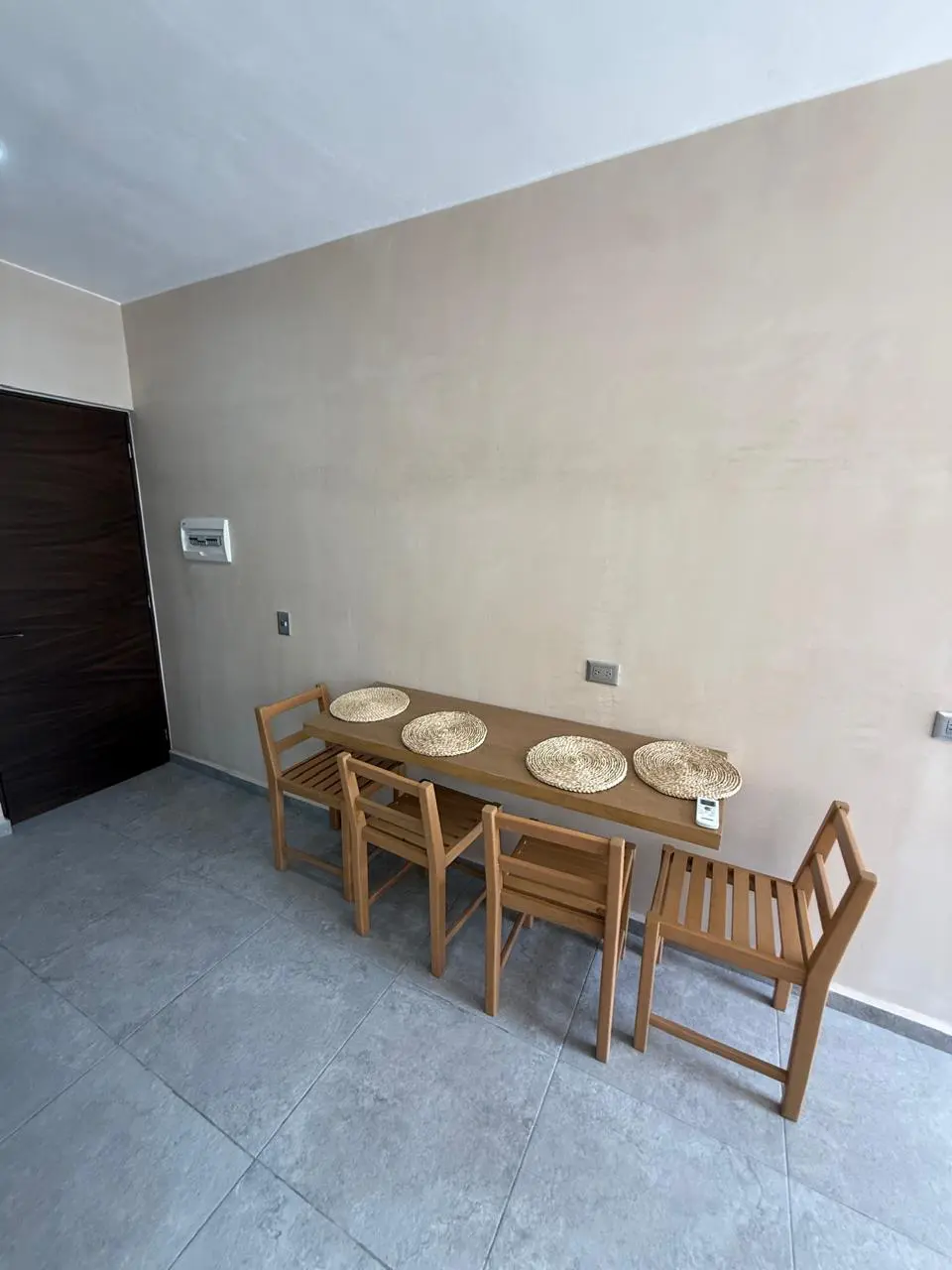 Narrow wooden dining table with four chairs