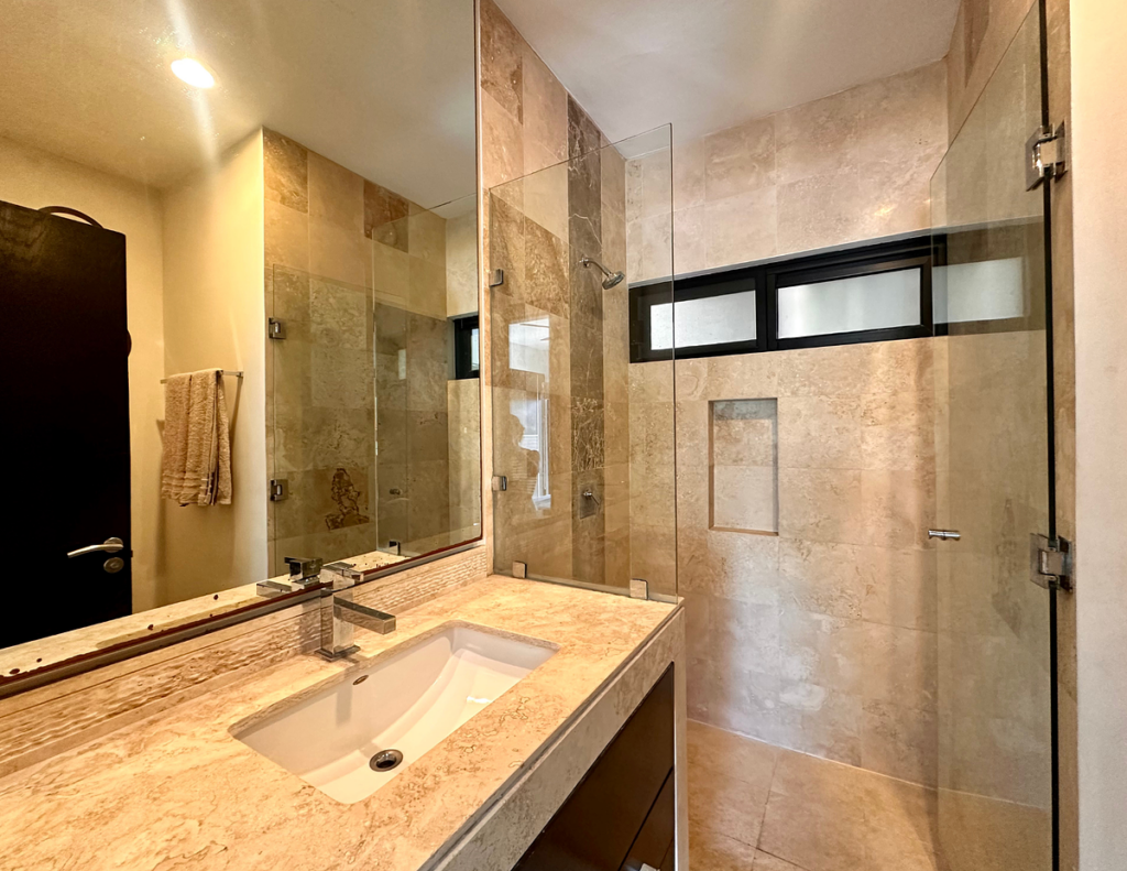 Modern beige tiled bathroom with glass shower