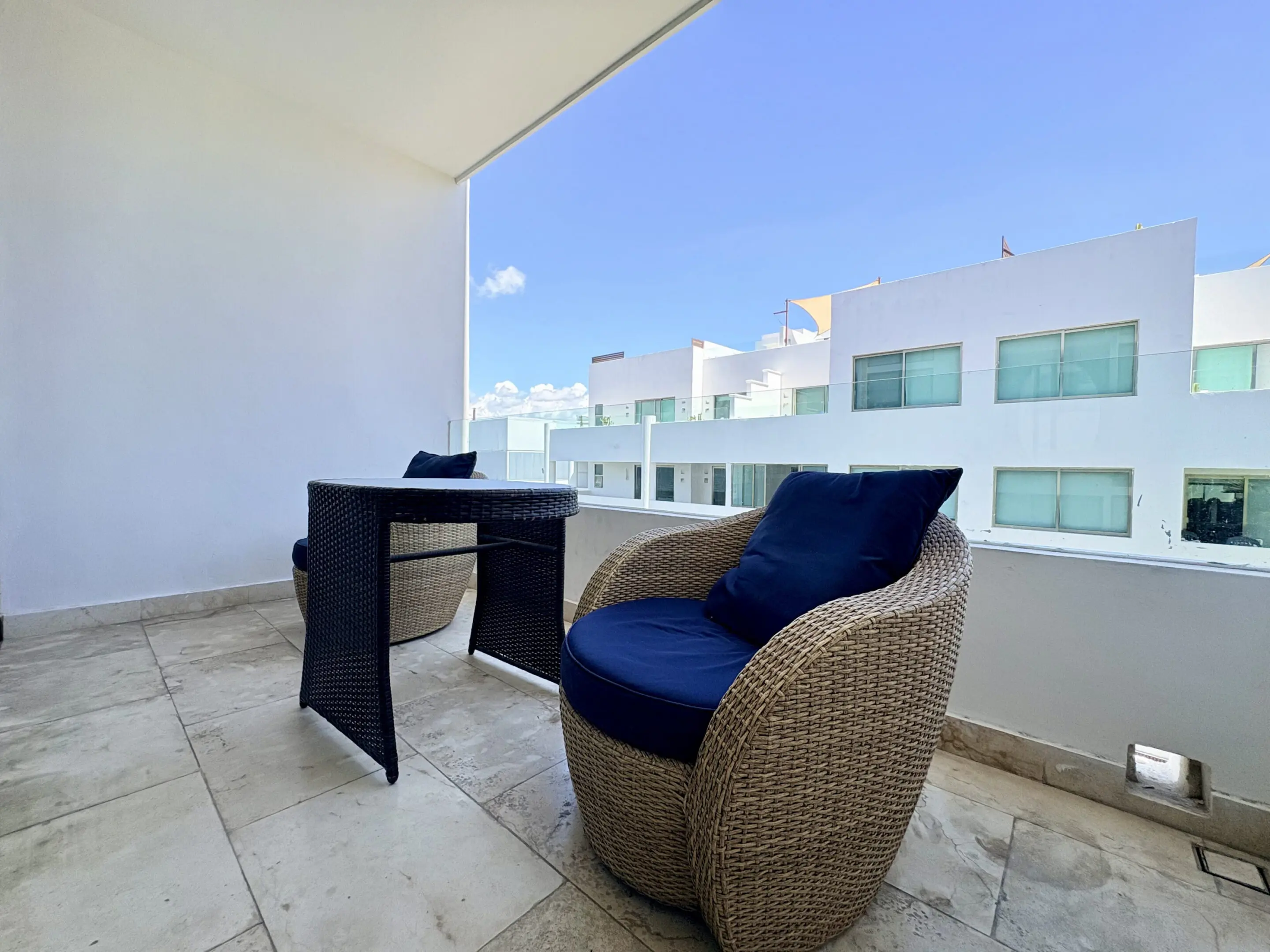 Modern balcony with wicker chairs and blue cushions