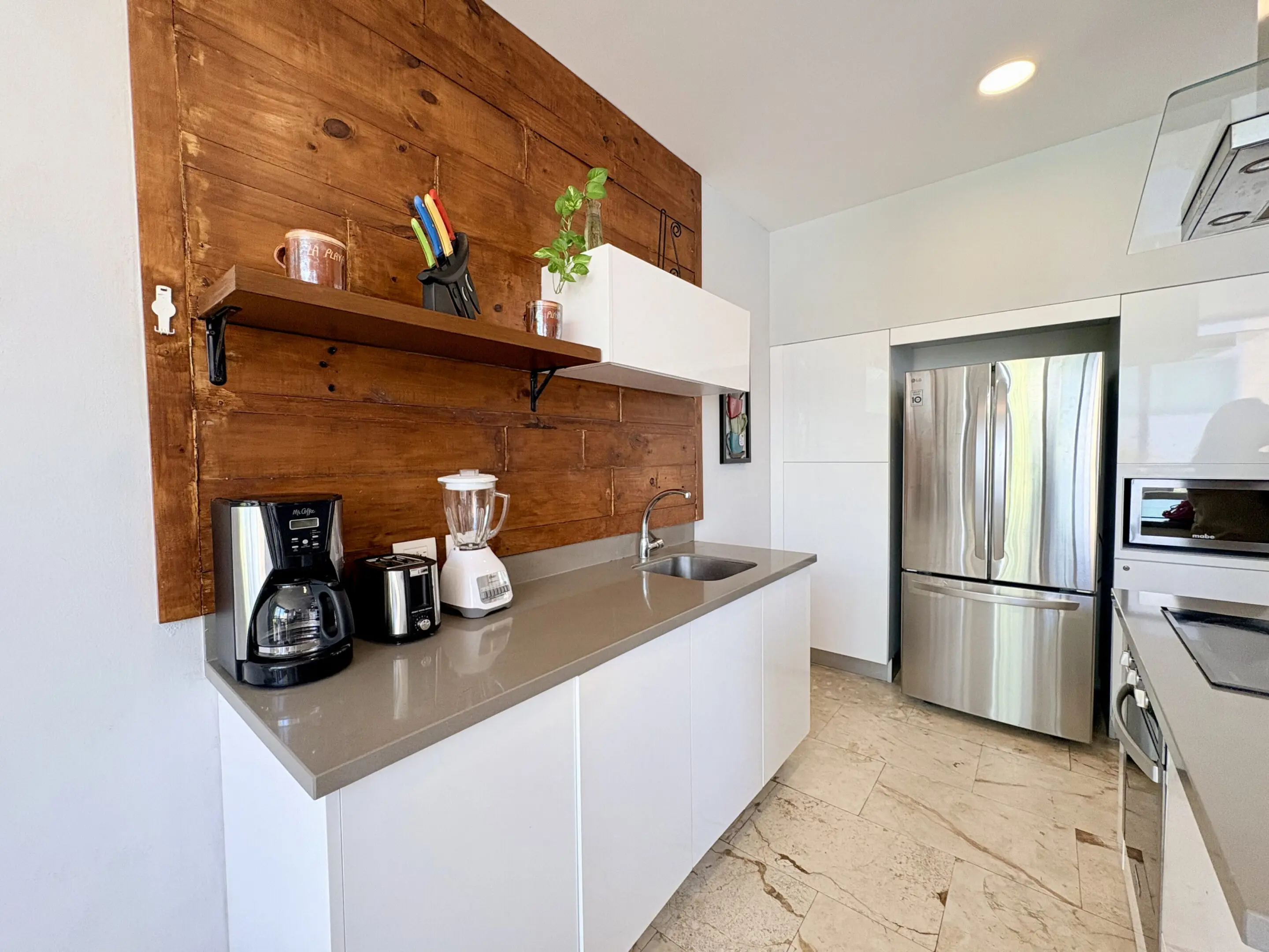 Modern kitchenette with appliances and wood backsplash