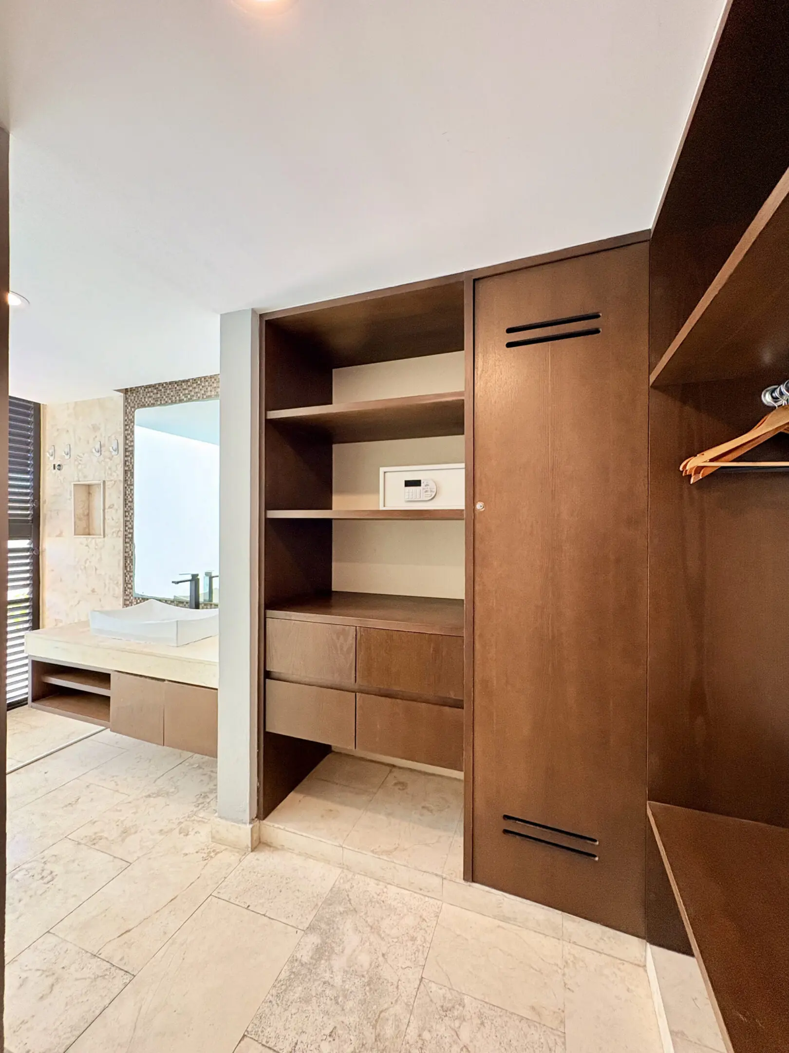 Built-in wooden closet with safe and bathroom