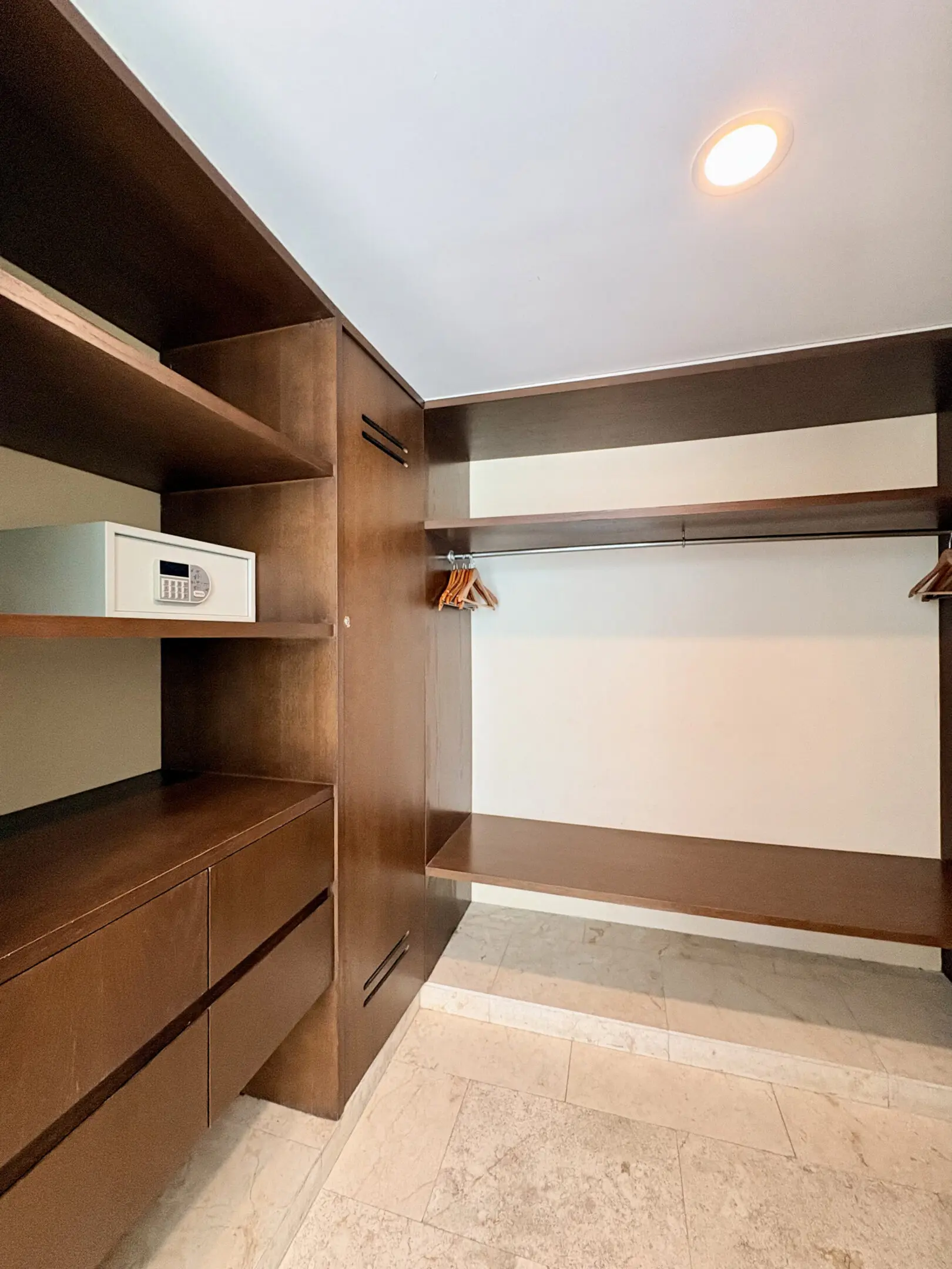 Walk-in closet with wooden shelving and safe
