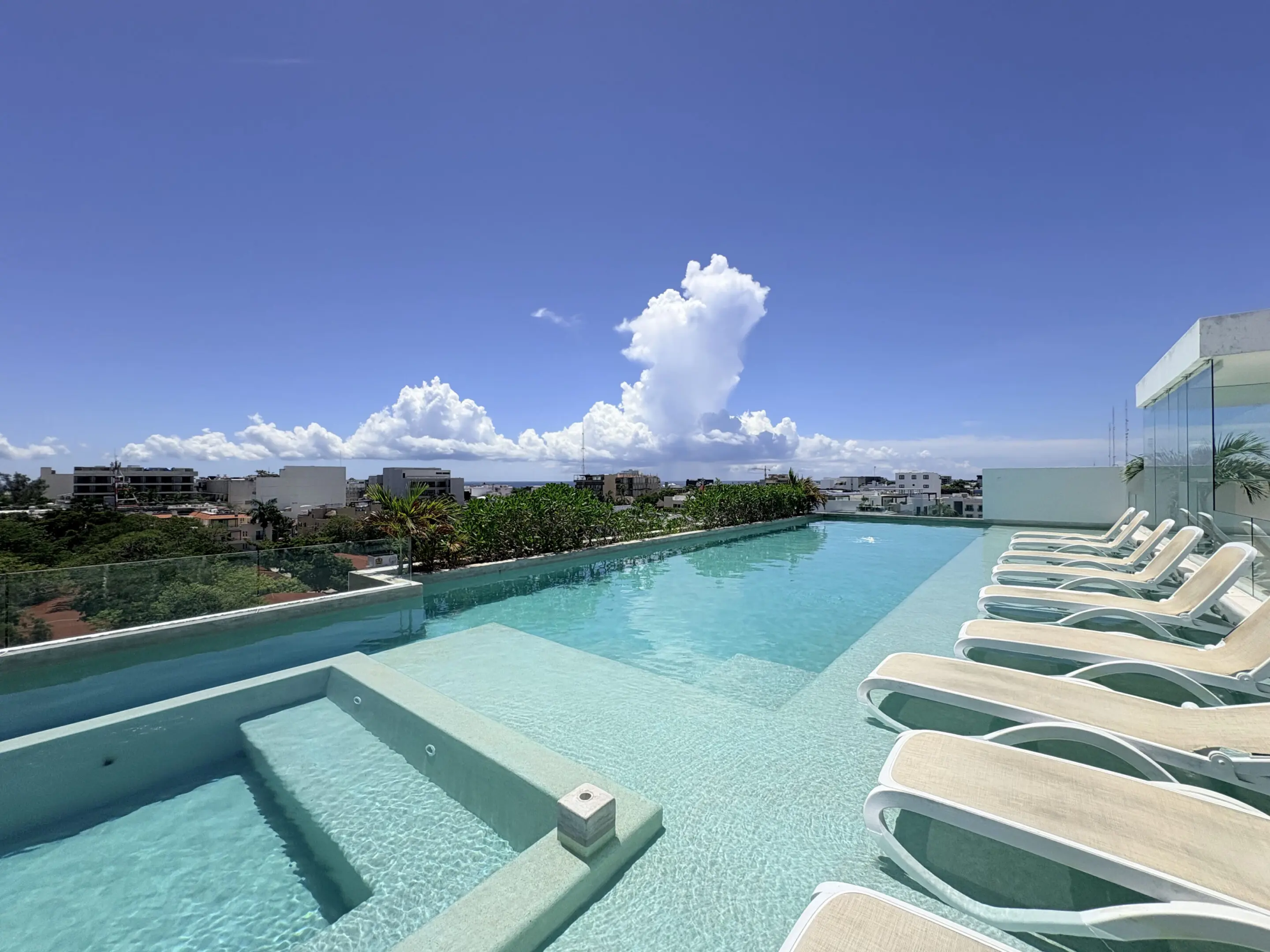 Rooftop infinity pool with lounge chairs and ocean