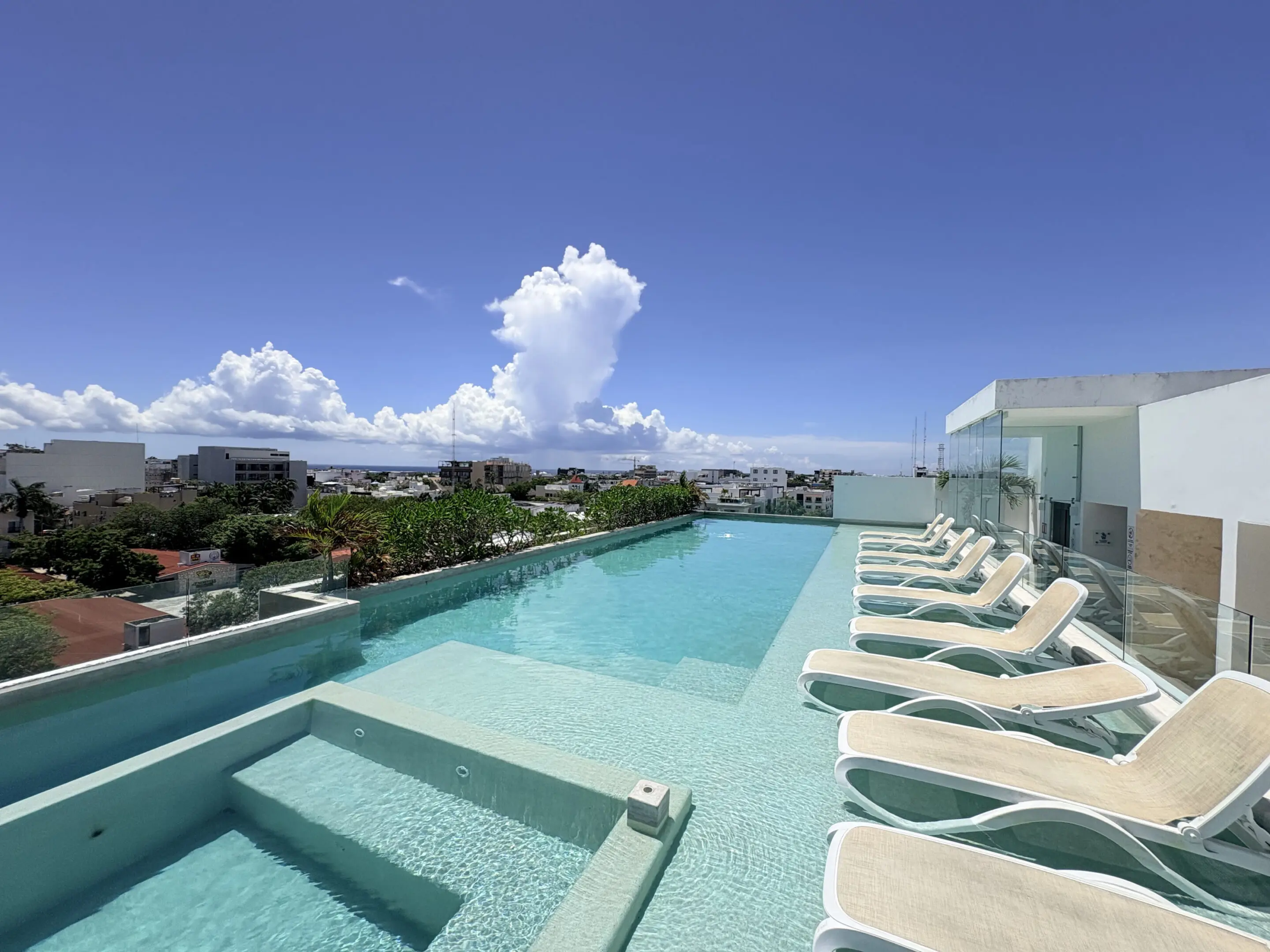 Rooftop infinity pool with lounge chairs