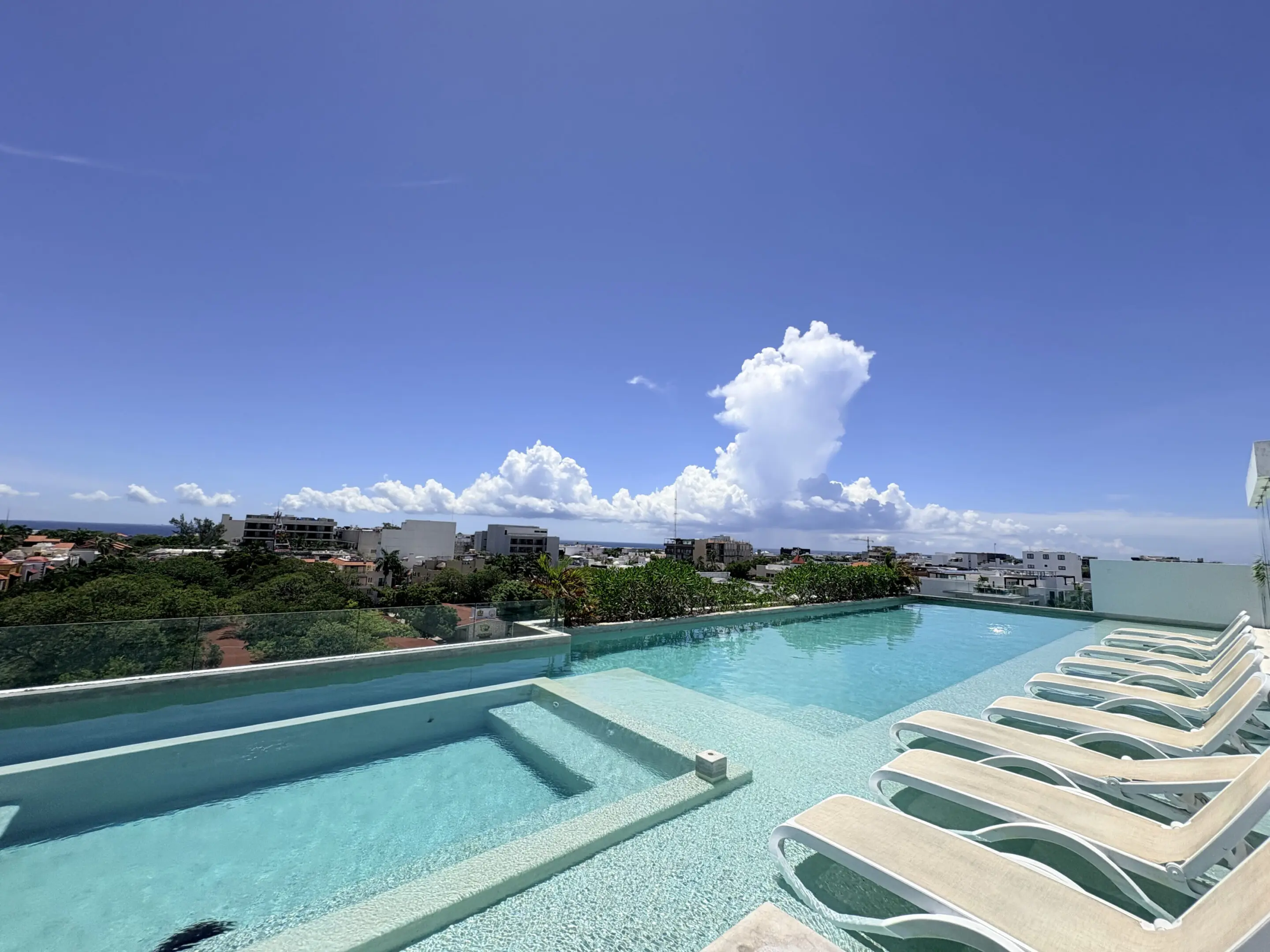 Rooftop infinity pool with lounge chairs